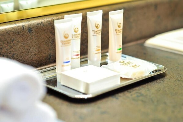 A tray with three tubes of Diamond Resort International products, a white book, and a small white object on a countertop.