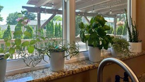 A kitchen with a window overlooking a garden and a pergola. - Playtime Paradise! Pool, Video Game Room, Pets OK! (Kennewick)