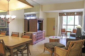 Ein Essbereich mit Holztisch und -stühlen, einem Fernseher und einem Schrank.