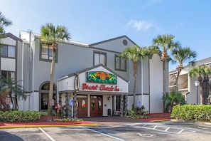 A building with a sign for 'Resort Check In' and palm trees in front.
