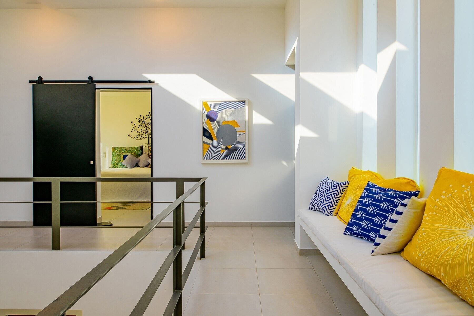 Una sala de estar moderna con un sofá, una mesa de centro y un puerta corredera que da a otra habitación.