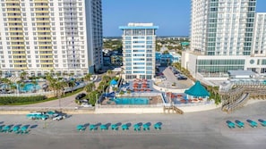 Un hĂŽtel comprenant plusieurs immeubles de grande hauteur, une piscine et des installations de loisirs en bord de mer.