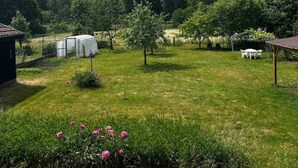 A grassy outdoor area with a small building, a covered structure, and a pavilion. - Can Appart 1 à 8 Pers (Granges-Aumontzey)