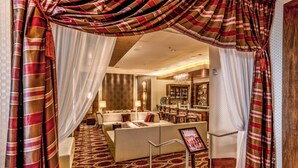 Een hotellobby met een zithoek, een bar en uitzicht op de bar.