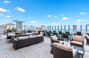 Une terrasse sur le toit avec des sièges extérieurs, un foyer et une vue sur l’océan.