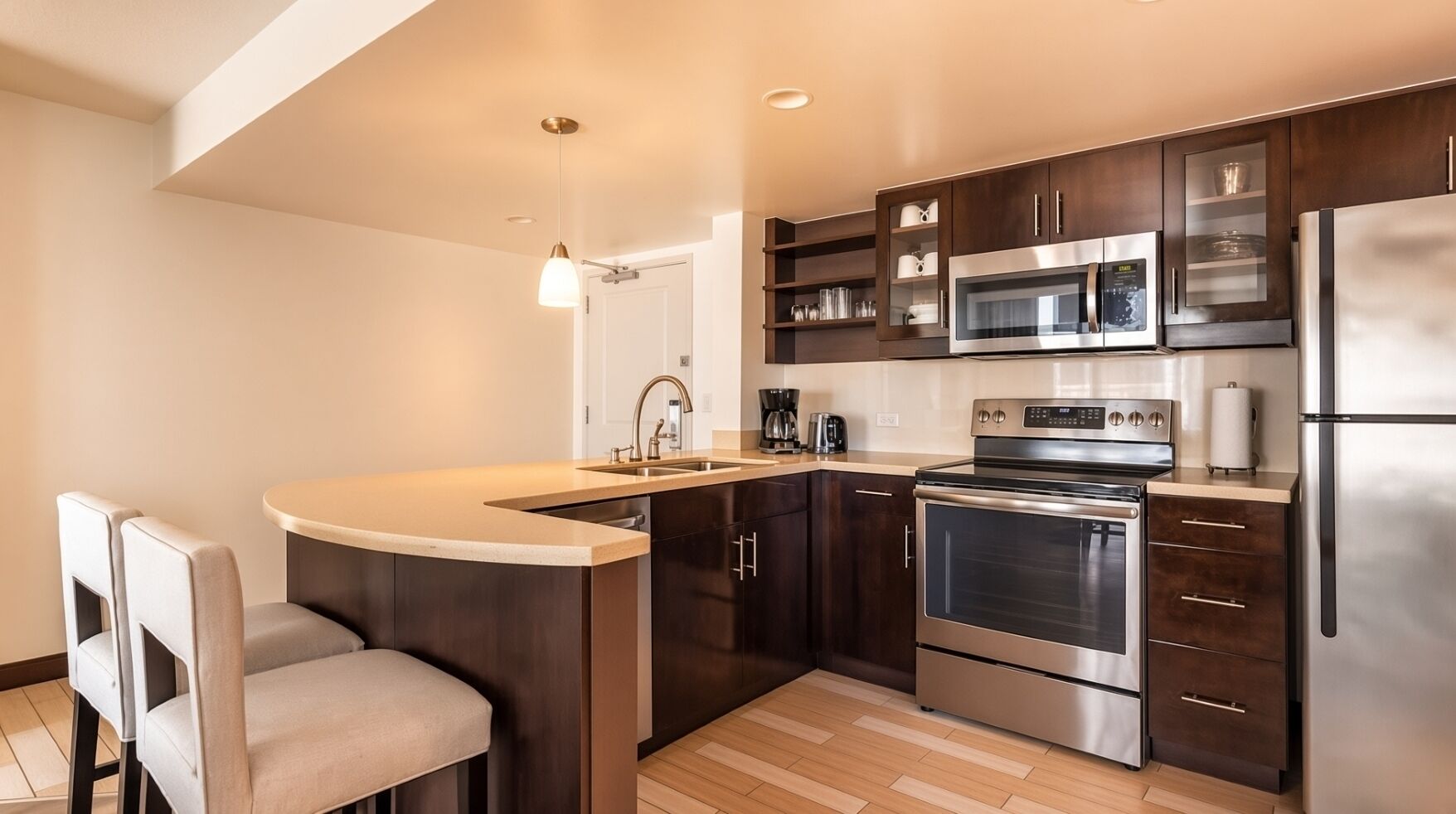 Una cocina moderna con una isla central, electrodomésticos de acero inoxidable y armarios de madera oscura.
