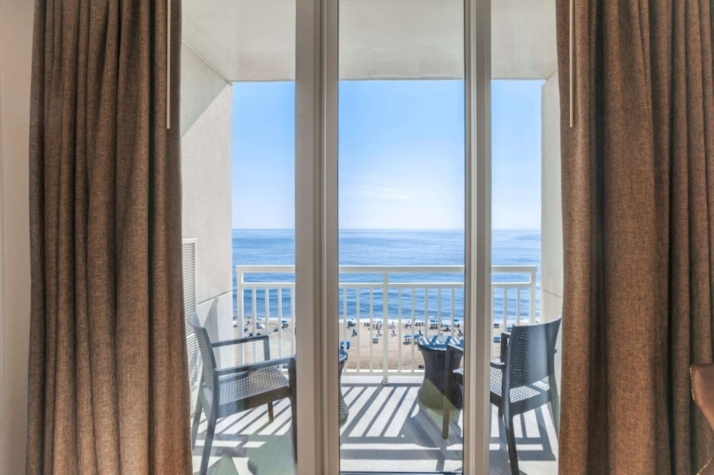 Un balcón con vista a la playa y al océano.