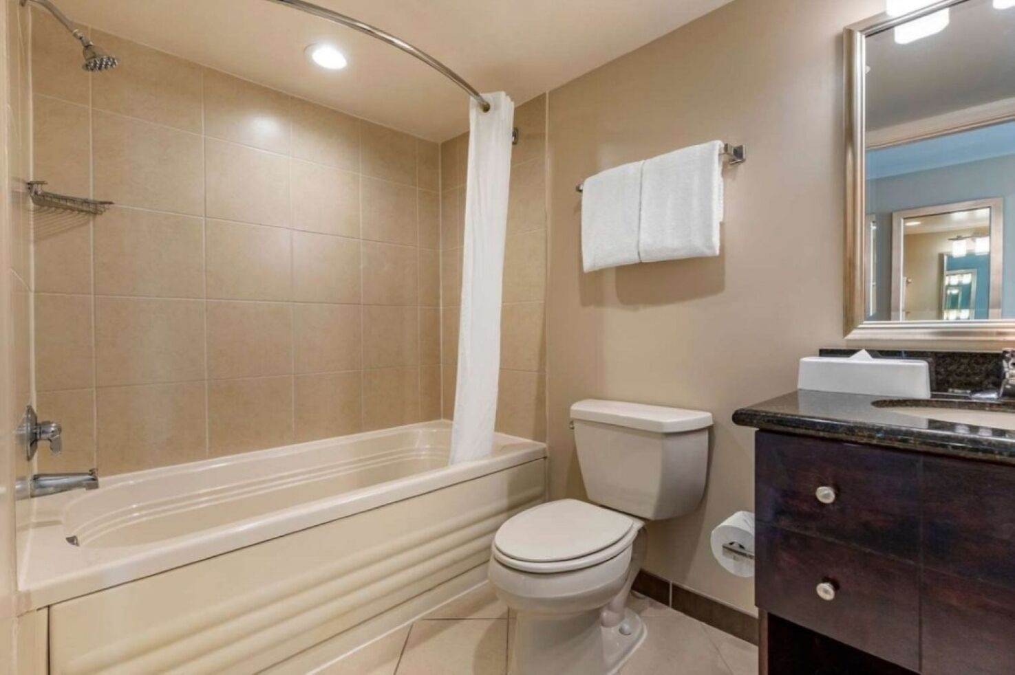 A bathroom with a bathtub, toilet, and vanity.