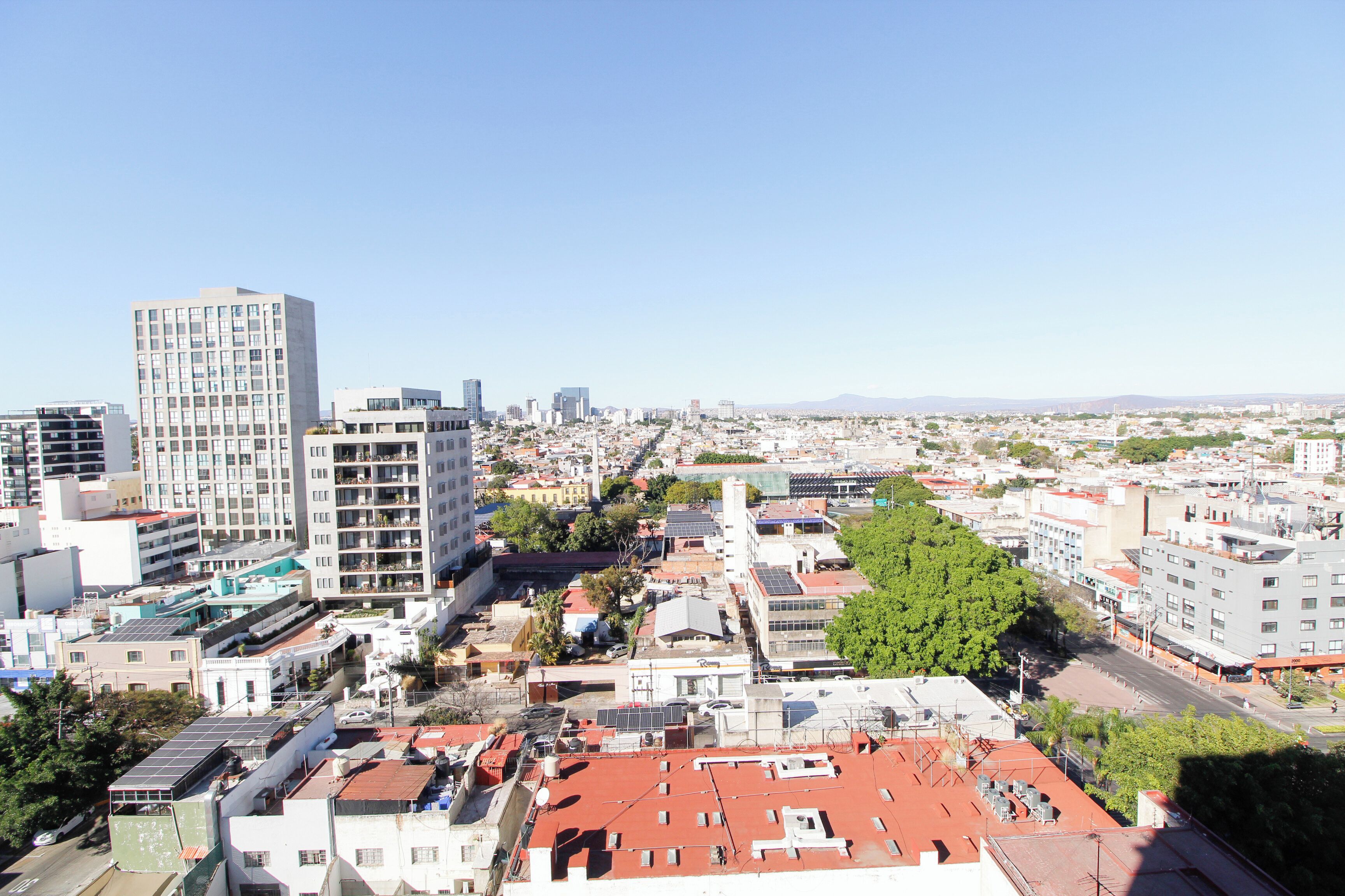 A cityscape with multiple buildings, including a prominent high-rise and several mid-rise structures.