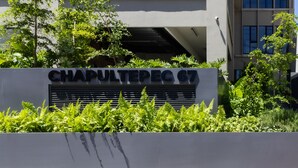 A sign for Chapultepec 67 with a modern building in the background. - Tribu Chapultepec 67 (Guadalajara)