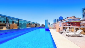 A rooftop pool with clear blue water, surrounded by modern buildings and lounge chairs. - 2BR Family Apt Puente de la Mujer View (Buenos Aires)