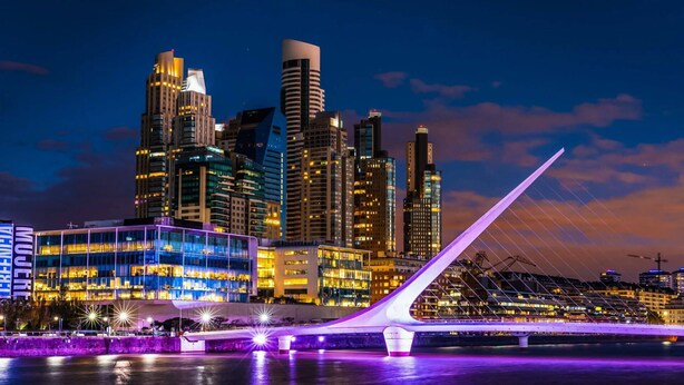 A city skyline with modern buildings and a bridge with a unique design. - 2BR Family Apt Puente de la Mujer View (Buenos Aires)