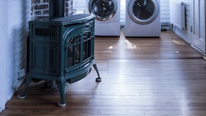 A laundry room with two front-loading washing machines, a vintage wood-burning stove, and a window with blinds. - Riverside Getaway! Minutes to Downtown Woodstock (Woodstock)
