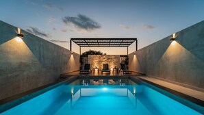 A swimming pool with a covered seating area and wall-mounted lights. - Hotel Mexico Merida (Mérida)