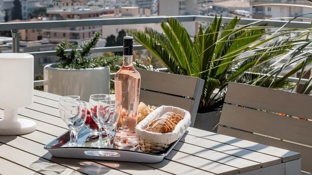 Terraza con una mesa lista para una comida, con vista a un paisaje urbano.