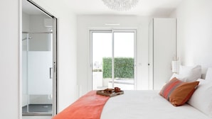 A modern bedroom with a large bed, a sliding glass door leading to a balcony, and a white wardrobe. - Stroll to Beach from Sea-View Penthouse with AC (Antibes)