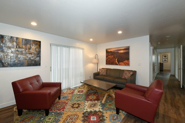 A modern living room with a sofa, two armchairs, a coffee table, and a patterned rug. - 2-B The Grand County Condo (Moab)