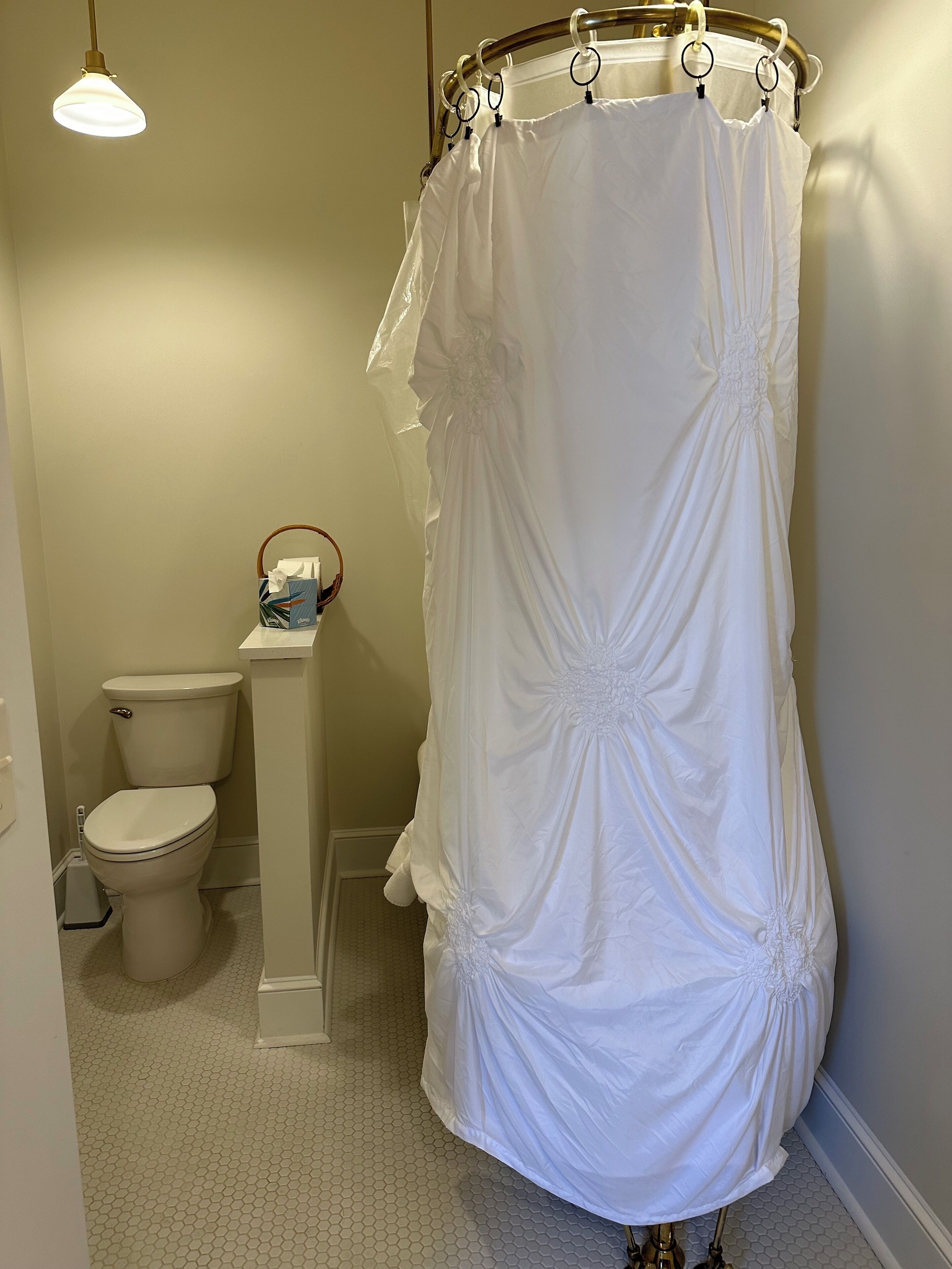 Un baño con inodoro blanco, lavamanos y cortina de ducha.