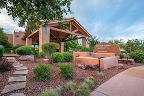 A building with a covered entrance, a sign reading "Sedona Summit", and a pathway leading to the entrance. - Diamond Resorts Sedona Summit - 3 Bedroom Sunset Suite (Sedona)
