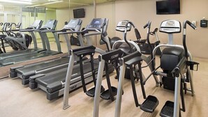 Een sportschool met meerdere loopbanden en elliptische trainers.