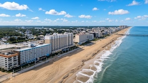 A coastal hotel with multiple floors, a beach promenade, and a pier extending into the ocean. - Virginia Beach | Ocean View Balcony Stay | Pool & Beach | Studio (Virginia Beach)