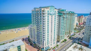 A high-rise hotel with multiple balconies, a beach view, and a parking area. - Virginia Beach | Ocean View Balcony Stay | Pool & Beach | Studio (Virginia Beach)