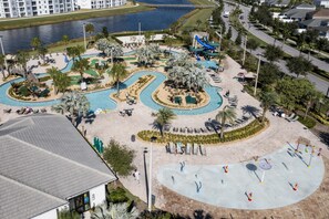 An aerial view of a resort with a swimming pool, palm trees, and a water slide. - 3119- Great Family Home near Disney, private pool, Storey Lake Resort. (Kissimmee)