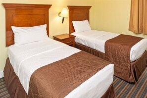 A hotel room with two beds, each with a wooden headboard, a nightstand, and a wall-mounted lamp. - Grand Beach - 3 Bedroom Full Mobility - Phase I (Orlando)