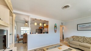 Una sala de estar con sofá, una mesa de centro y una zona de comedor con sillas y mesa.