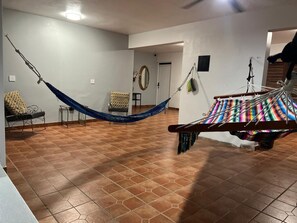 A spacious living area with a large hammock, a sofa, and a small table.