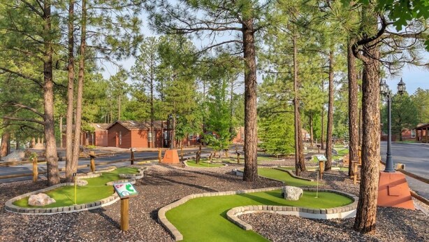 A miniature golf course with a wooden cabin in the background. - Pinetop | Family Cabin Retreat |  local hikes | 2BR (Pinetop)