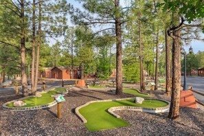 Ein Minigolfplatz mit einer Holzhütte im Hintergrund.