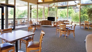 A spacious indoor area with tables and chairs, large windows, and a television. - Ramona | Couples Country Retreat | Pool + Tennis (Ramona)