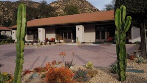 A building with a red-tiled roof, white walls, and a paved driveway. - Ramona | Couples Country Retreat | Pool + Tennis (Ramona)