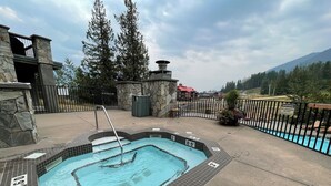 Una piscina con indicatori di profondità e un cartello che indica 'No Diving', circondata da muri in pietra e una recinzione metallica.