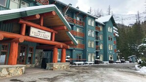 Una lodge a più piani con un cartello che riporta "Snow Creek Lodge & Cabins".