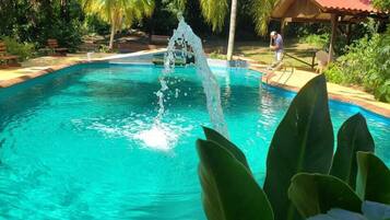 Una piscina al aire libre de temporada, sombrillas