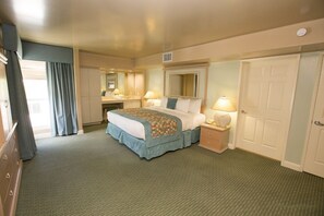Ein Hotelzimmer mit Bett, Nachttischen, Schreibtisch, Spiegel und Kleiderschrank.