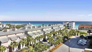 Un hôtel situé sur la côte, avec des maisons mitoyennes, un parking et une vue sur l’océan.