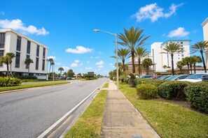 A street with buildings, a sidewalk, and parked cars.