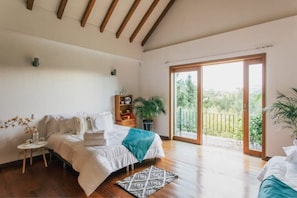 A bedroom with a bed, a small table, a potted plant, and a view of greenery outside. - Luxury, Near Airport, 4 Bd, Fast Internet, Events
 (Rionegro)