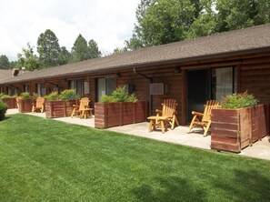 A row of log cabins with outdoor seating and planters. - Payson | Peaceful Cabin Stay | Pool + Hot Tub (Payson)