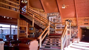 Un interior de madera con una escalera, estanterías y una pared de piedra.