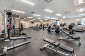 A gym with various exercise equipment, including treadmills, ellipticals, and weight machines.