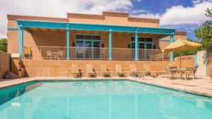 A pool area with lounge chairs and a covered patio.