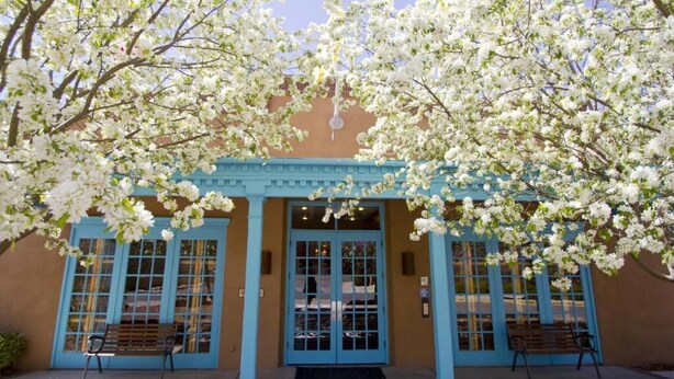 A building with a blue facade and a covered entrance area.
