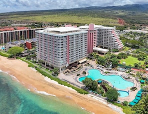 A resort with multiple high-rise buildings, a beachfront, and a large swimming pool.