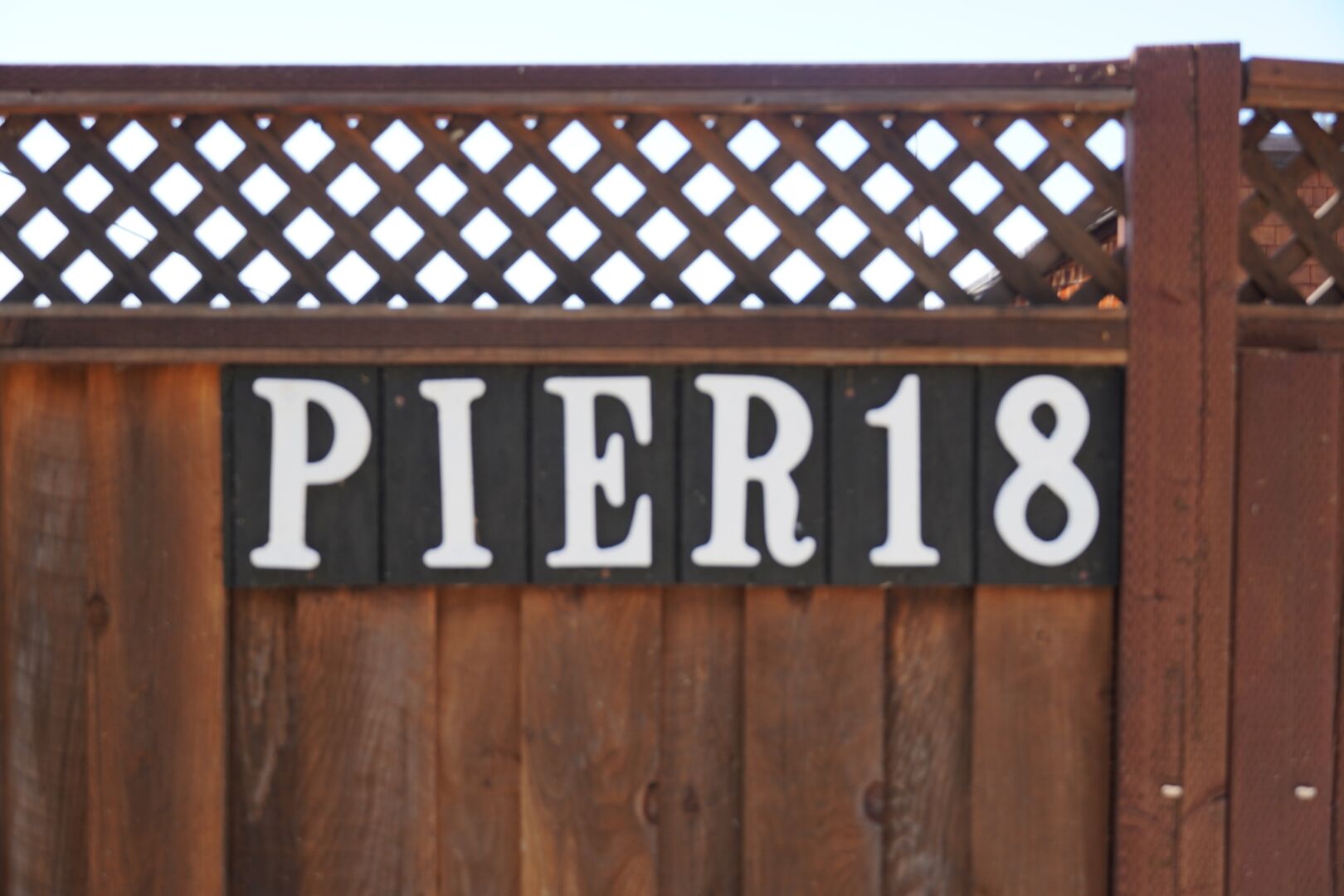 Ett trästaket med en skylt som visar texten ”PIER18”.