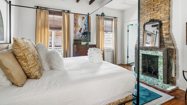 Un dormitorio con cama, chimenea y vistas al exterior.