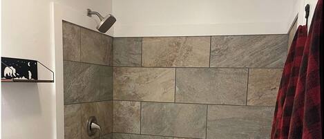 A bathroom with a shower, toilet, and bathtub.